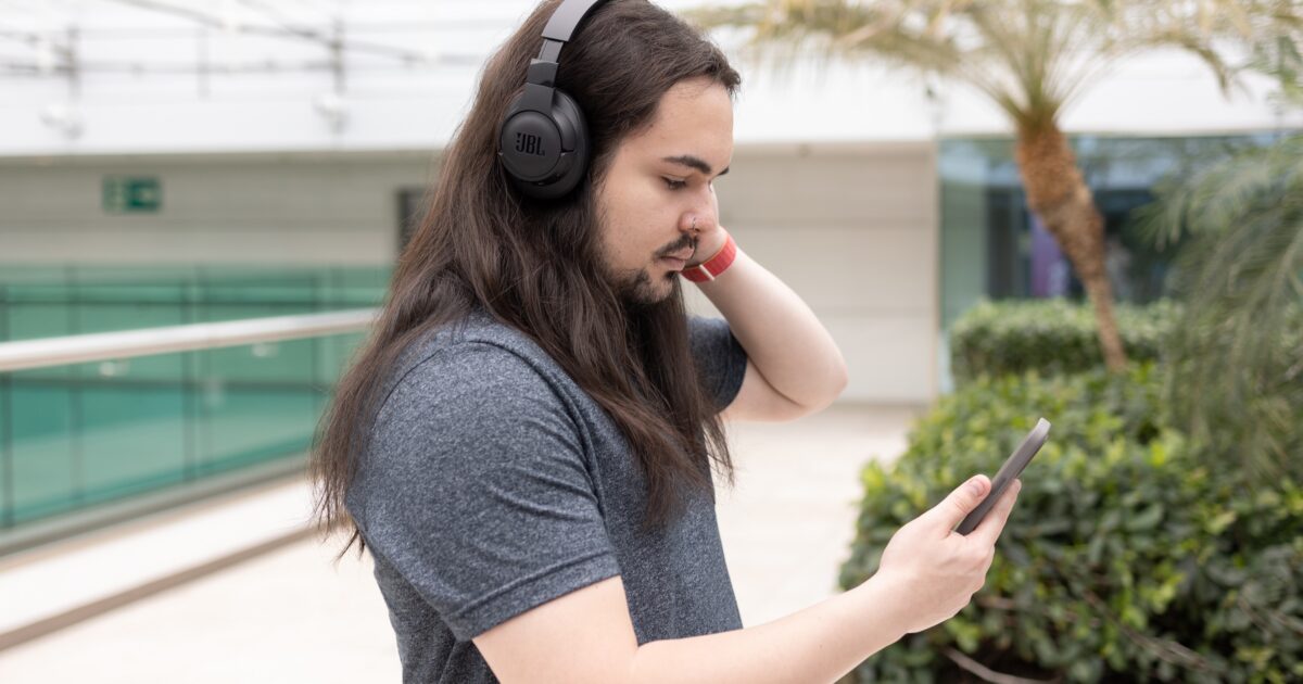 Vários fones de ouvido bluetooth de diferentes modelos e marcas dispostos sobre uma superfície escura com iluminação dramática, mostrando desde opções compactas TWS até headphones premium over-ear