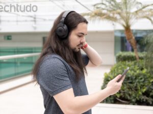 Vários fones de ouvido bluetooth de diferentes modelos e marcas dispostos sobre uma superfície escura com iluminação dramática, mostrando desde opções compactas TWS até headphones premium over-ear