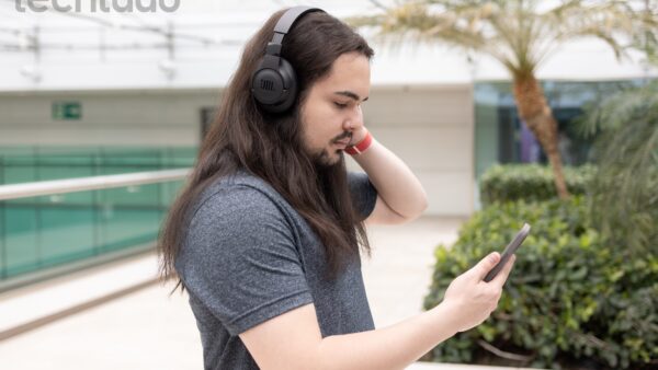 Vários fones de ouvido bluetooth de diferentes modelos e marcas dispostos sobre uma superfície escura com iluminação dramática, mostrando desde opções compactas TWS até headphones premium over-ear