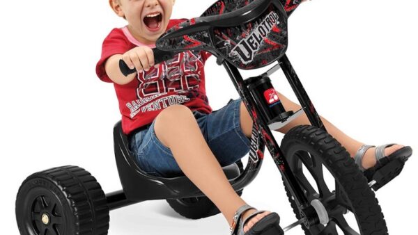 Criança pequena no triciclo velotrol com empurrador